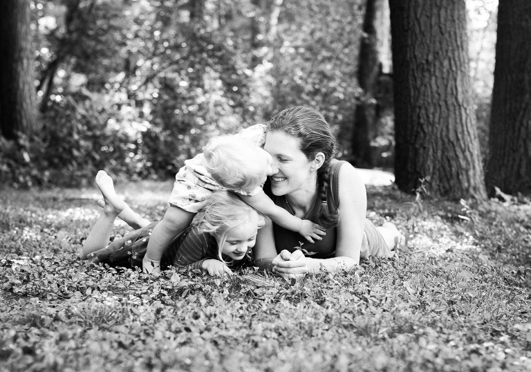 black and white candid photo of mom and two daughters